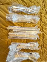 Bundled flatware pieces individually wrapped in plastic sleeves