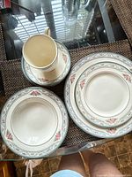 Top view of assorted plates, bowl, cup and saucer showing pattern and quantity