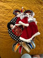Two holiday dolls, porcelain guard doll, partial jester mask headpiece visible