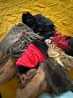 Pile showing assorted scarves, shawls and faux fur pieces