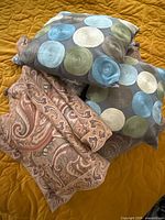 Stack showing paisley and embroidered circle pillows