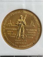 Obverse of medal showing miner, metals text and commemorative rim legend