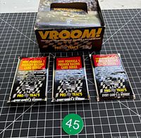 Lot overview showing three sealed packs in front of original display box