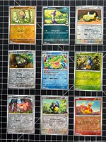 Group shot of nine reverse holo Pokémon cards laid out 3×3 on grid mat