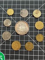 Obverse sides of nine assorted coins and tokens displayed on grid