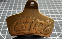 Front view showing raised Drink Coca-Cola logo and brass finish