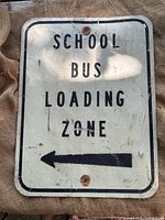 Front view of SCHOOL BUS LOADING ZONE sign showing text and arrow