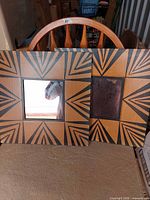 Two square geometric patterned wood mirrors on chair