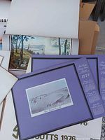 Stack of calendars showing duplicate purple-border 1972 editions, Scouts 1976 and rolled scenic pages