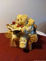 Front view of teddy bear piggy bank showing figures reading a book