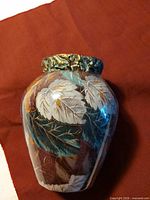 Front view of cloisonné vase showing multicolour leaf pattern and metal collar