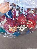 Front view of clear bag showing multiple coloured yarn balls