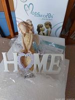 Front view of figurine showing HOME lettering, heart O with rhinestones and overall design