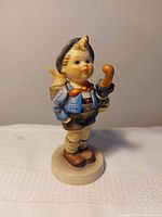 Front view of Goebel Hummel Home From Market figurine on base