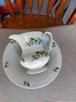 Pitcher nested in matching wash basin showing floral pattern and scale