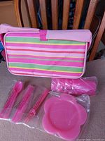 Exterior of striped picnic bag with utensils, napkin and plate shown sealed