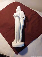 Full view of white glazed porcelain figurine standing on base