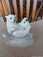 Front view of polar bear cub figurine on frosted base