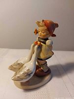 Front view of Goose Girl figurine showing girl and two geese