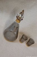 Overhead view showing decanter and two shot glasses, pattern and gold accents visible