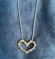 Close view of sterling silver heart pendant spelling LOVE on chain