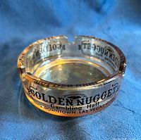 Amber glass ashtray showing full branding