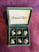 Closed green Marshall Field’s box open to show six fruit place card holders in compartments