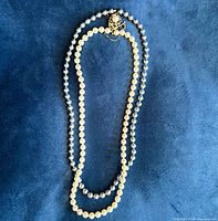 Full view of necklace showing alternating cream and grey faux pearls