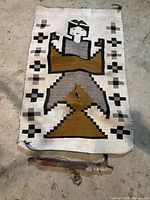 Full view of woven cradleboard cover showing figure and damage