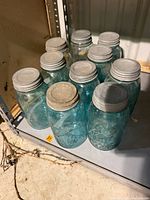 Group of nine aqua blue Ball mason jars on shelf