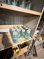 Group of aqua Ball jars with lids on metal shelving