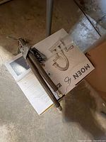 Box top showing Moen faucet image with taped braided supply lines