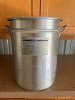 Front view of aluminum Bayou Classic stock pot with loop handles and label