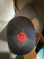 Top view of black Beats hard case showing red logo and surface scuffs