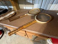 Both wooden rackets and cover on workbench