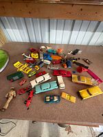 Top view of entire assortment of die-cast cars, plastic parts, figures and wheels on table