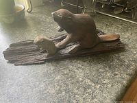 Side view of mother and baby beaver wood sculpture on driftwood base