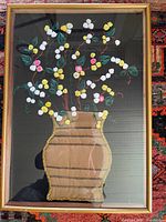 Front view showing entire framed textile artwork with vase and flowers