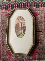 Full view of framed etching showing octagonal frame and mat