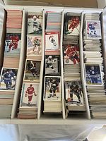 Overall view of four-row long box filled with hockey trading cards, several visible brands and players