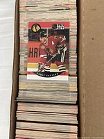 Open storage box filled with stacked Pro Set hockey cards; visible top card shows Chris Chelios Chicago Blackhawks