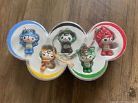 Front view of five mascot keychains in clover-shaped case
