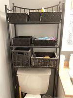 full view of metal shelf over toilet with baskets on three tiers