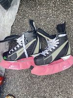 Pair of skates with pink blade covers shown side profile