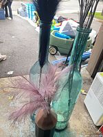 Two tall teal glass vases with stems and one medium vase with pampas grass