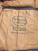 Close-up of JC Higgins Simpsons Sears logo, model 1038 and Made in Canada stamp on glove cuff