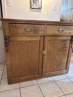 Front view of solid wood sideboard showing drawers, doors, brass pulls, wear