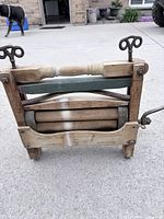 Front view showing Superior name, wood frame, green painted bar, rubber rollers, tension screws