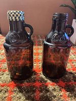 Two amber glass mini growlers side by side, showing overall form and one screw cap