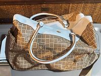 Full view of Anne Klein monogram duffle showing exterior pattern, light blue trim, handles and strap